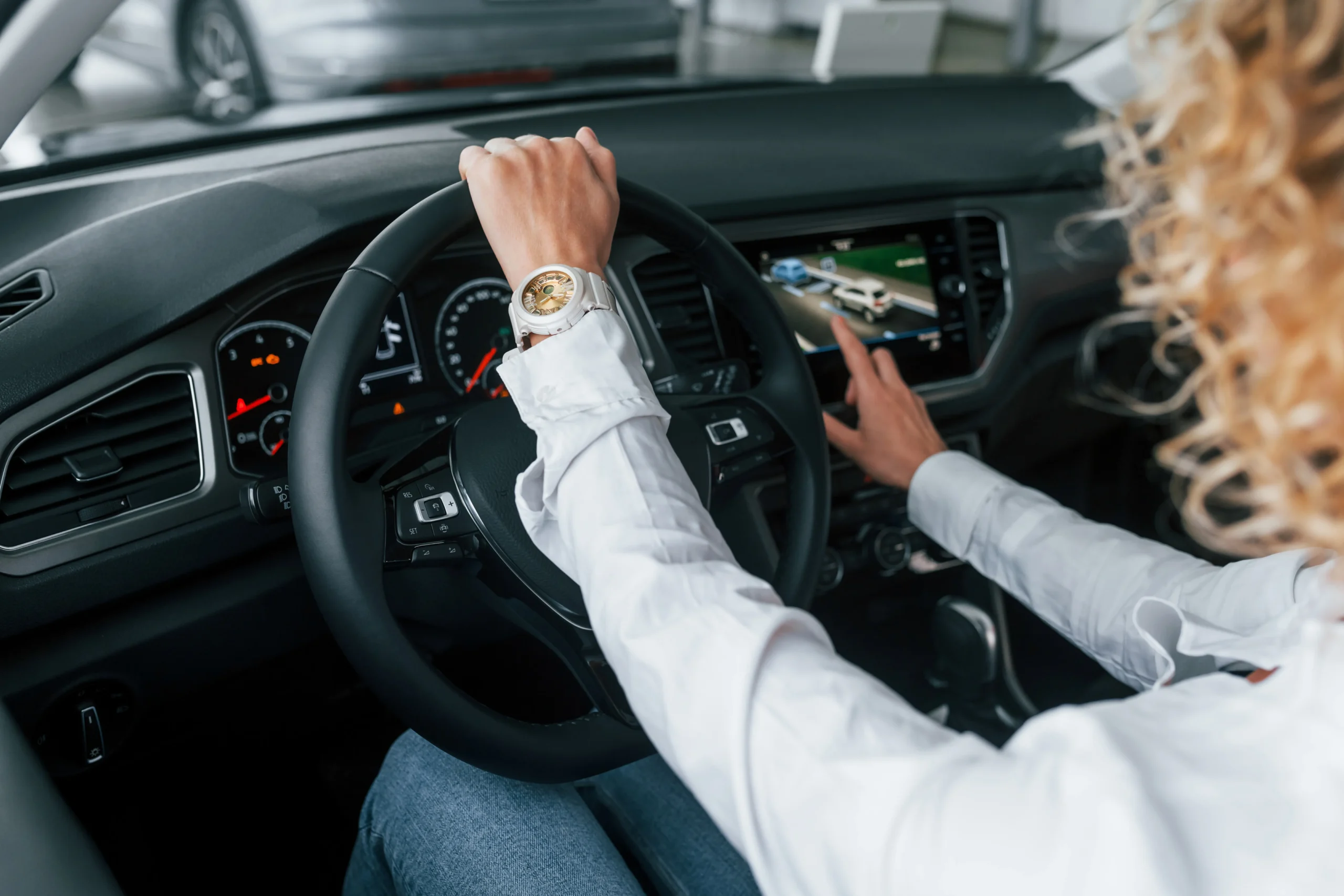 a woman putting her hand on steering of a luxury car